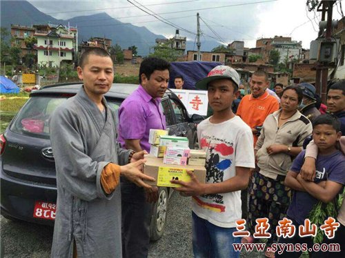 当地灾民双手接过中勇法师救援物品